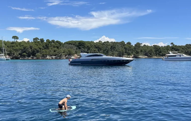 Luxury yacht in pristine waters in Cannes Lerins Islands during a sunny day with a guest enjoying water toys