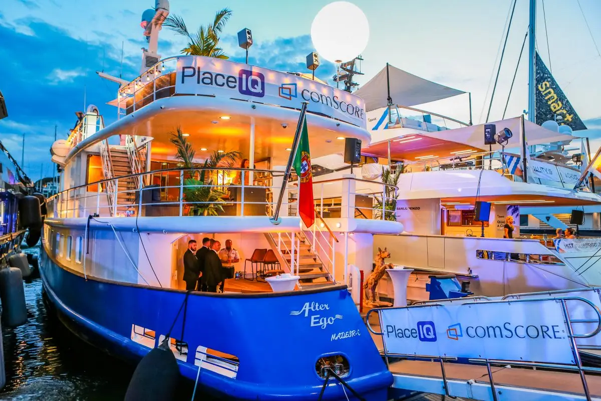 Blue branded yacht moored at the quay in Cannes with a white balloon above the deck