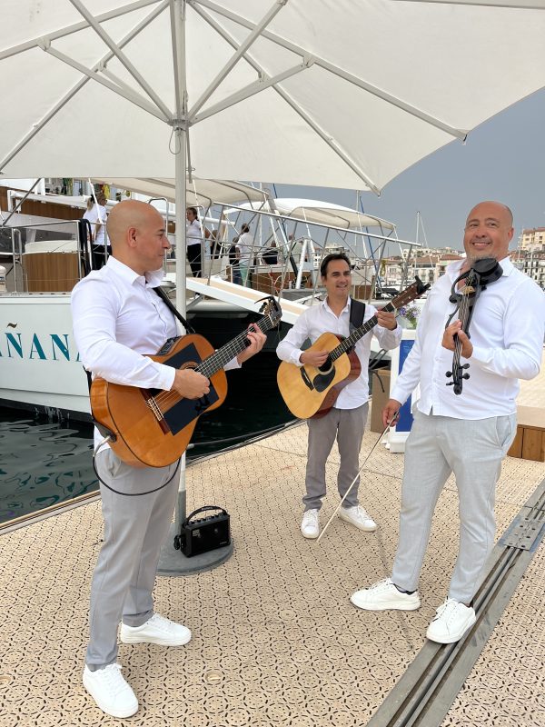 Musicians playing guitars on a yacht deck in Cannes