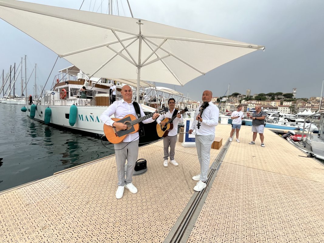 Musicians playing on the quay beside a charter yacht in Cannes