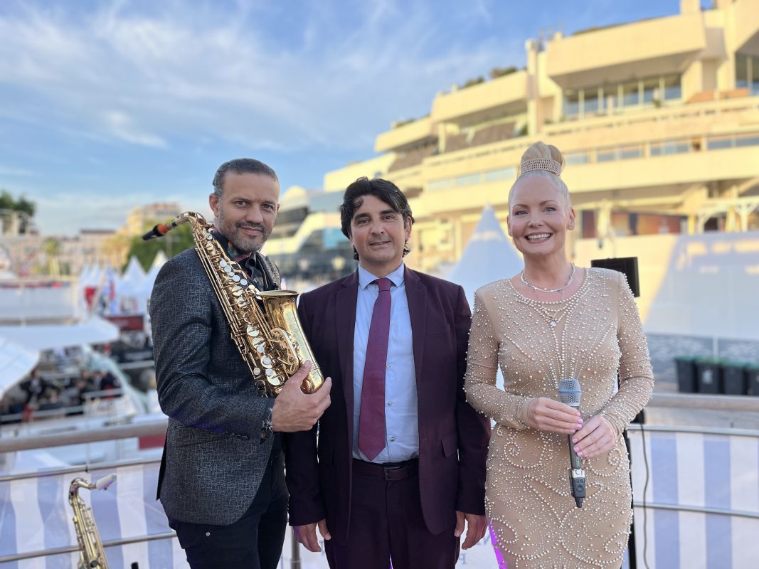 Saxophonist posing with two guests on a yacht in Cannes
