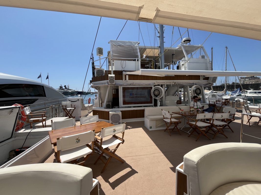 Upper deck of a charter yacht with a lounge and dining area in the Cannes marina