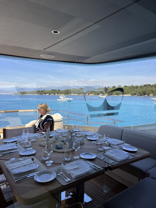 Table set for lunch on a yacht deck with a view of the bay of Cannes