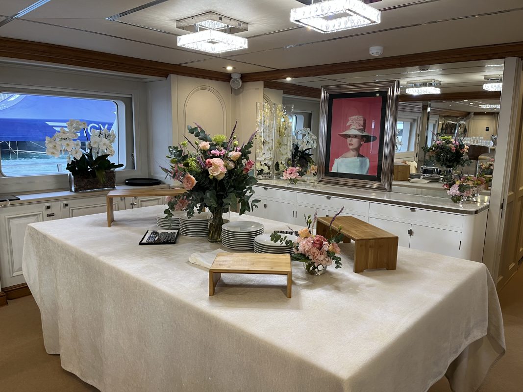 Meeting room on a charter yacht with a buffet table and fresh flowers