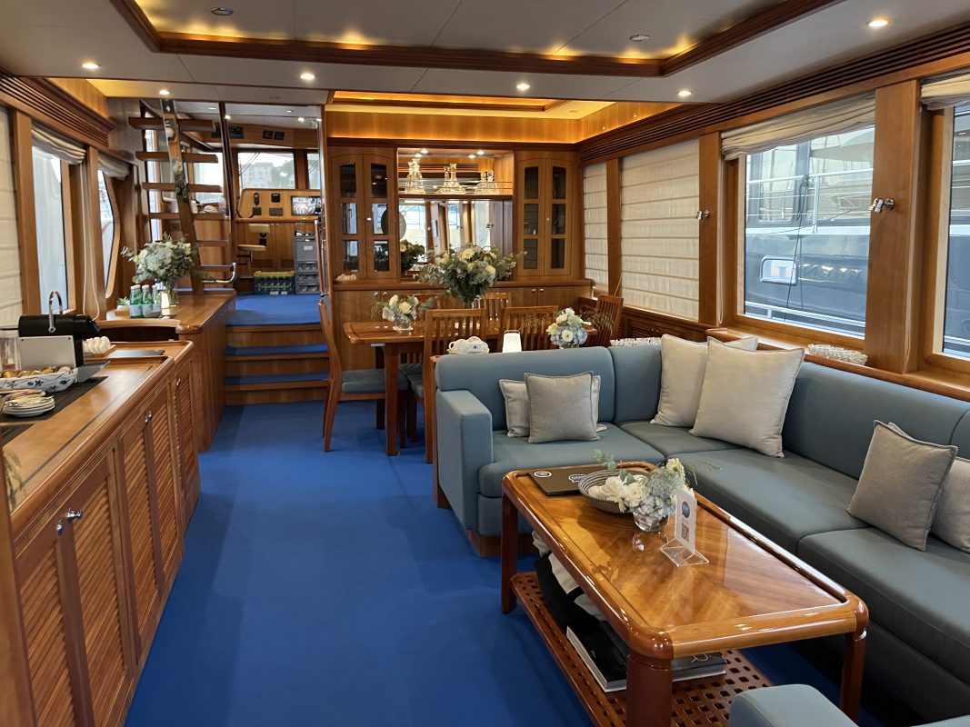Salon of a charter yacht with sofas, wood paneling and a coffee table