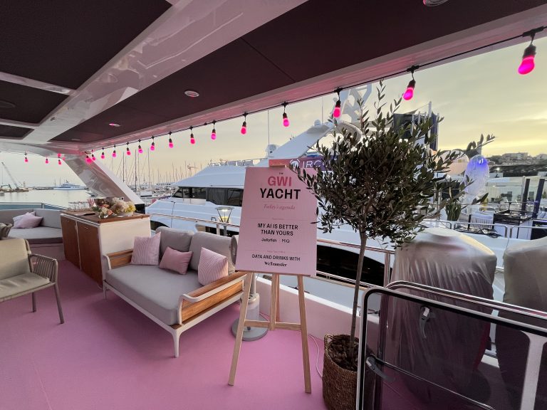 Yacht deck with a lounge and pink lighting in the Cannes marina at sunset